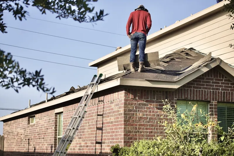 Professional roofer working on a residential roof in John J Delaney Homes
